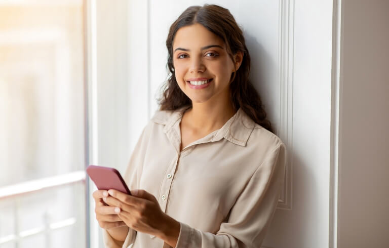 happy-young-woman-holding-smartphone-and-smiling-w-2024-03-25-23-33-29-utc (1)