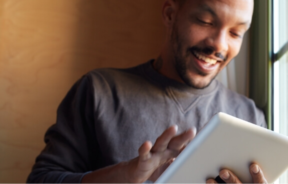 smiling-african-black-man-using-tablet-at-home-liv-2023-11-27-05-13-33-utc (1)